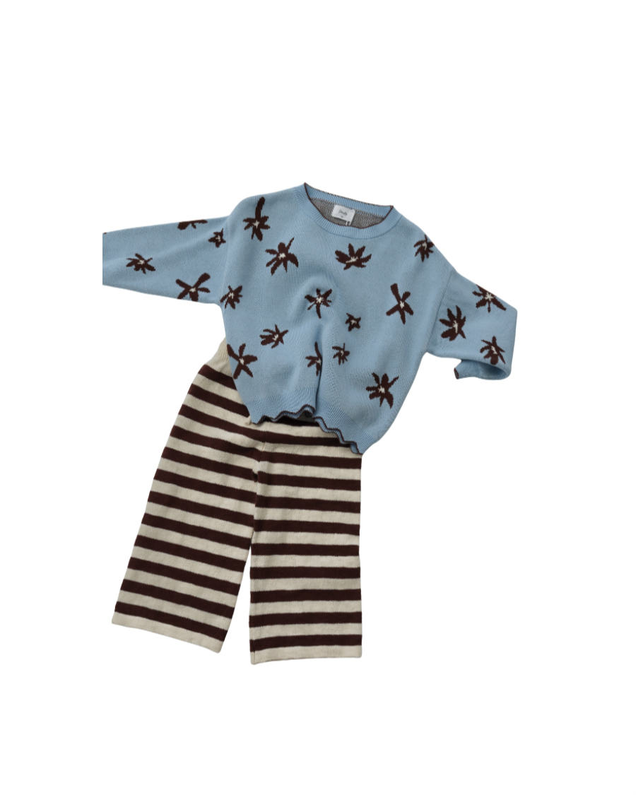 Children's outfit with blue sweater and striped pants on a white background
